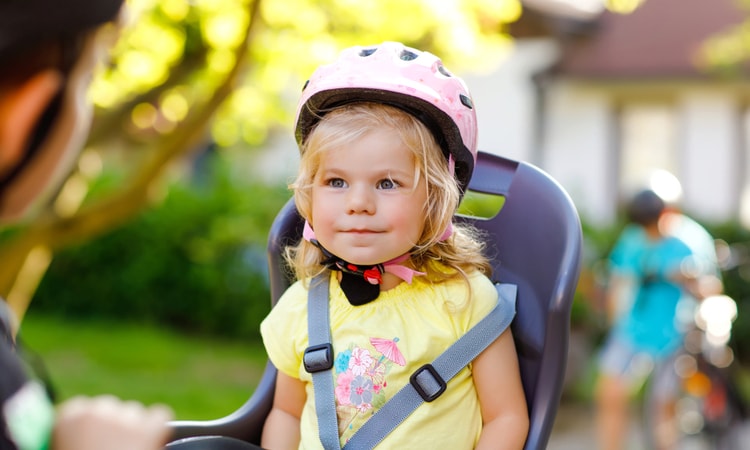 ребенок сидит в велокресле