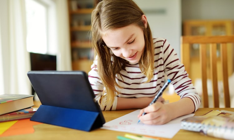 ребенок учится за планшетным компьютером