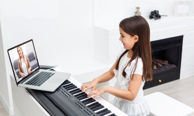 девочка учится играть на пианино