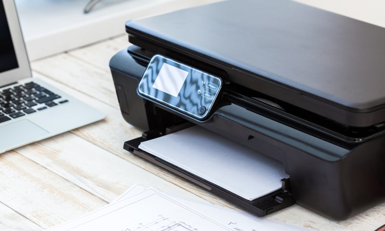 черный принтер с электронным дисплеем и загруженной бумагой