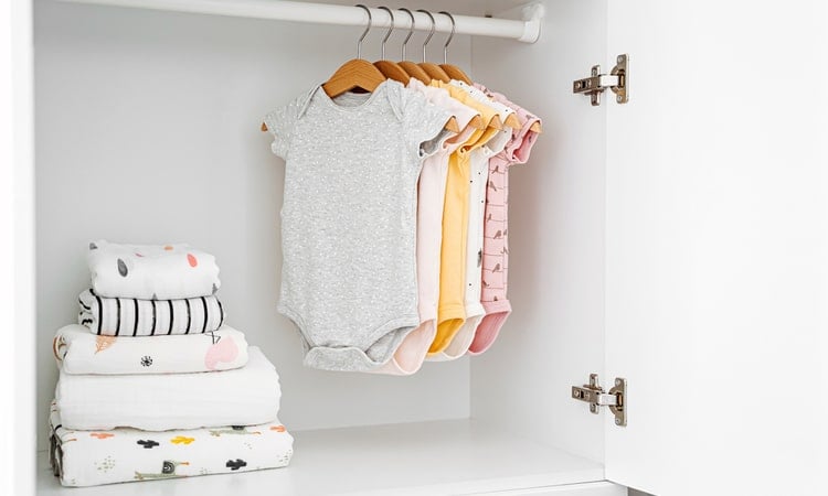 в шкафу висит одежда для новорожденных