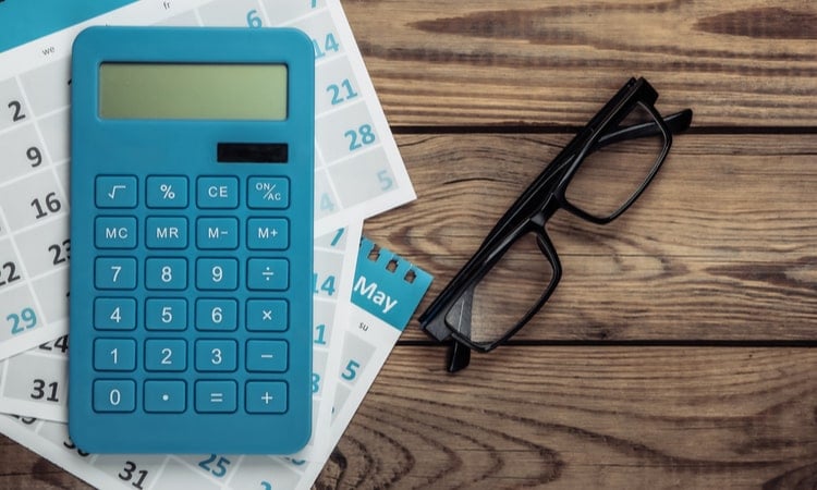 синий калькулятор и очки на столе
